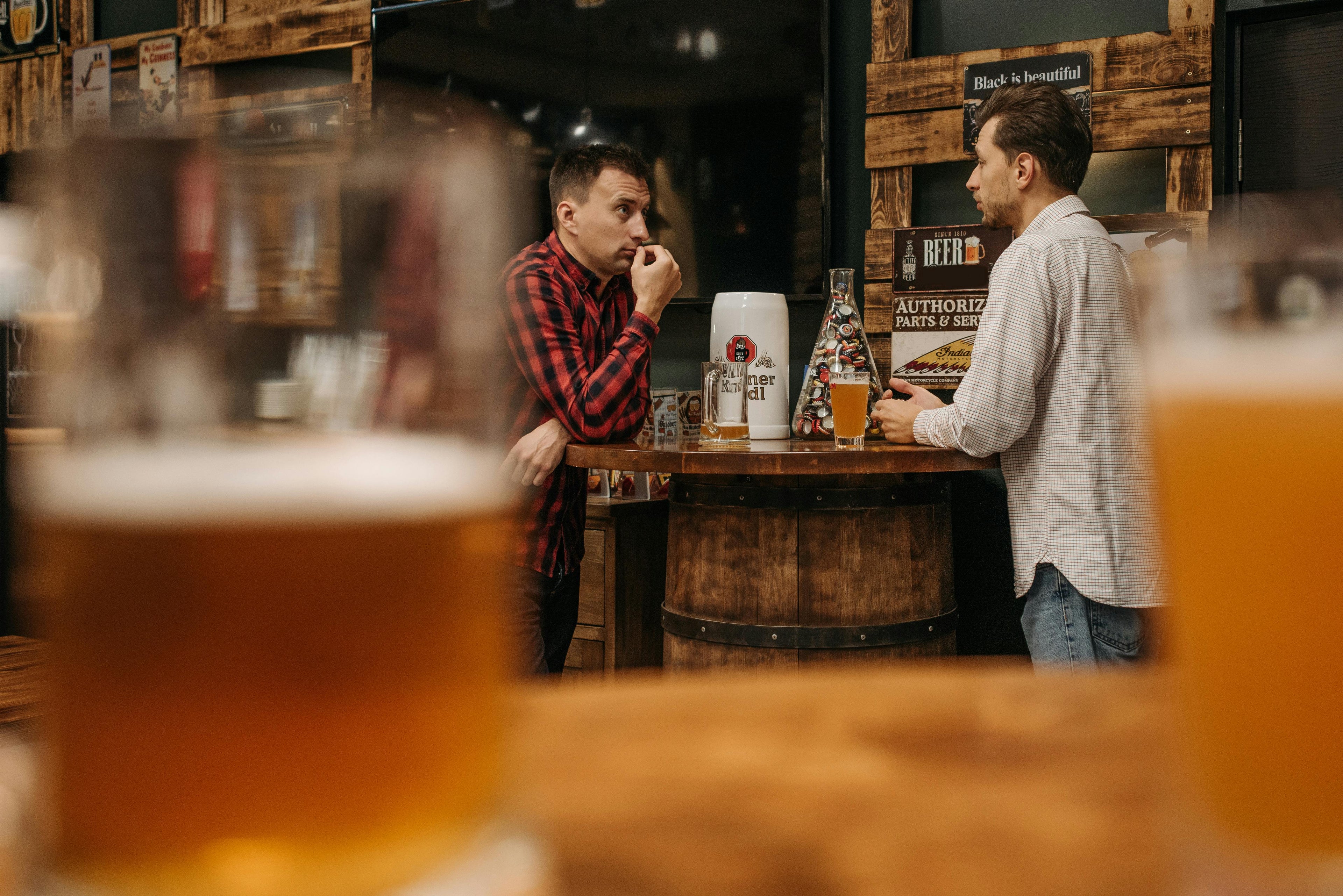 Zwei Männer bei einem geselligen Bierabend, umgeben von verschiedenen Biersorten und Braukunst