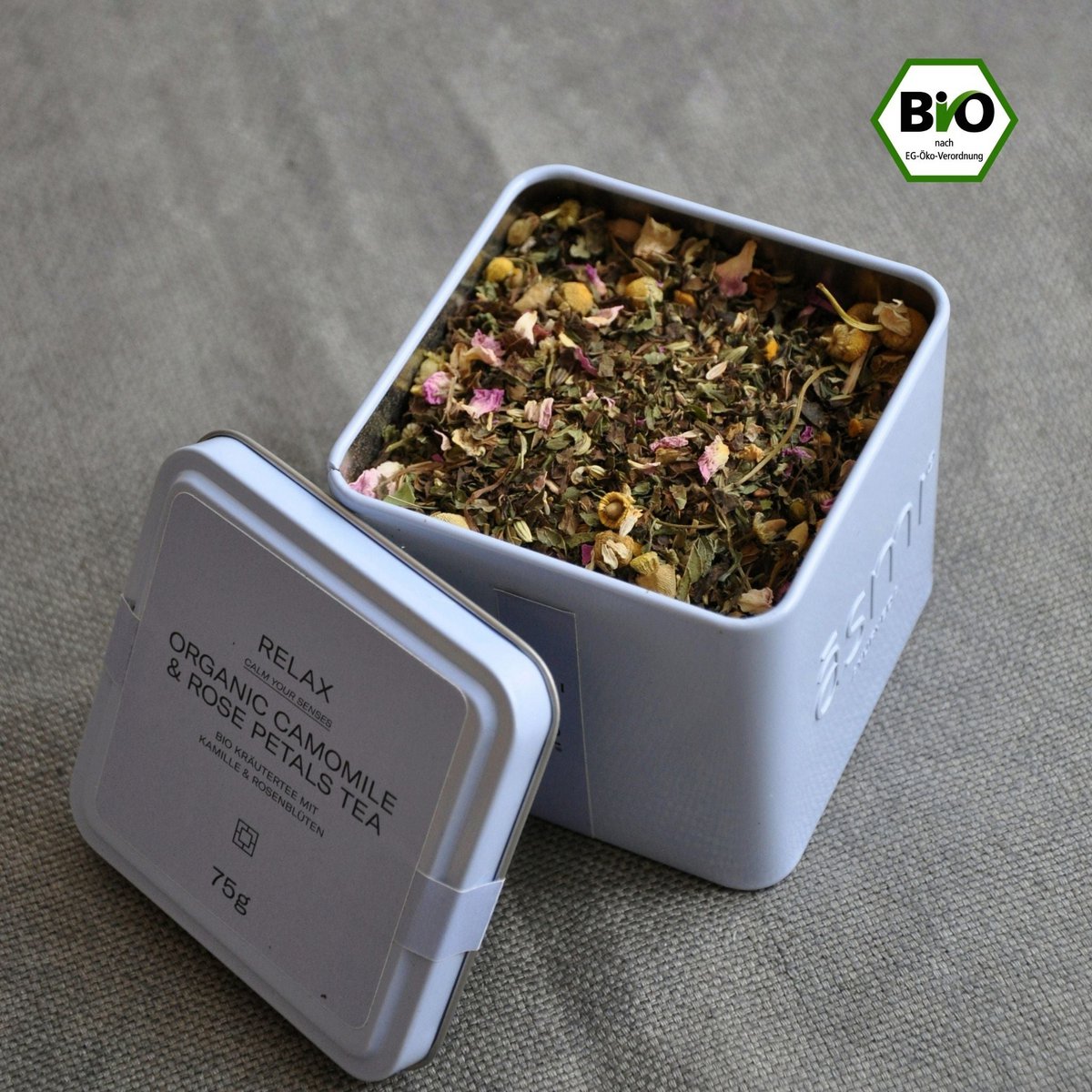 Āsmi Ayurveda Kamillen Tee mit Rosenblütenblätter in weißer Metallbox mit Bio-Siegel