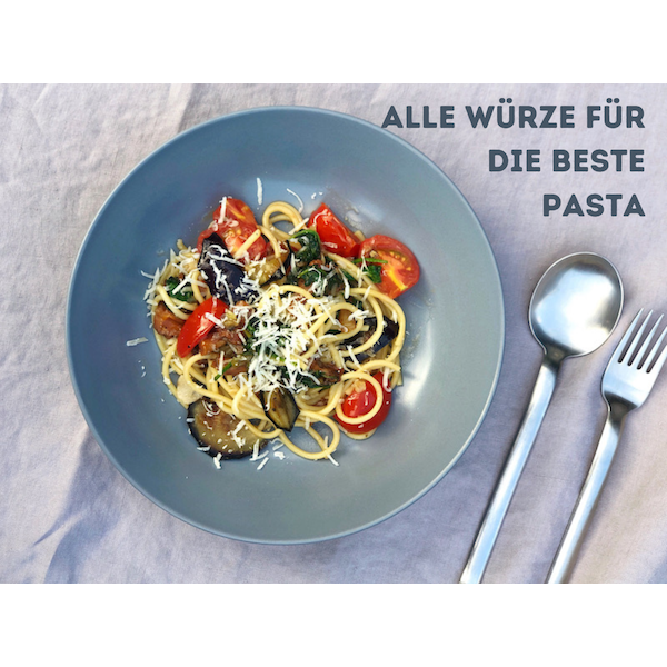 Reise Gewürzset kaufen für Pasta mit frischen Tomaten, Auberginen und geriebenem Käse auf blauem Teller